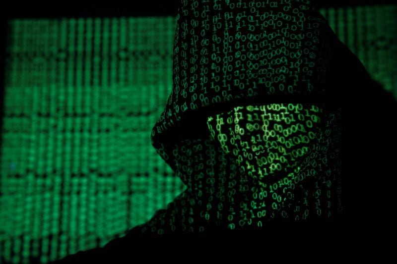Ilustración fotográfica que muestra un código cibernético reflejado en un hombre encapuchado. REUTERS/Kacper Pempel