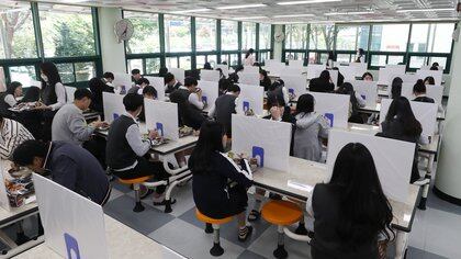 High school students eat a lunch at a school cafeteria which has screens on tables for preventing infections, as schools reopen following the global outbreak of the coronavirus disease (COVID-19), in Ulsan, South Korea, May 20, 2020. Yonhap/via REUTERS       ATTENTION EDITORS - THIS IMAGE HAS BEEN SUPPLIED BY A THIRD PARTY. NO RESALES. NO ARCHIVE. SOUTH KOREA OUT. NO COMMERCIAL OR EDITORIAL SALES IN SOUTH KOREA.
