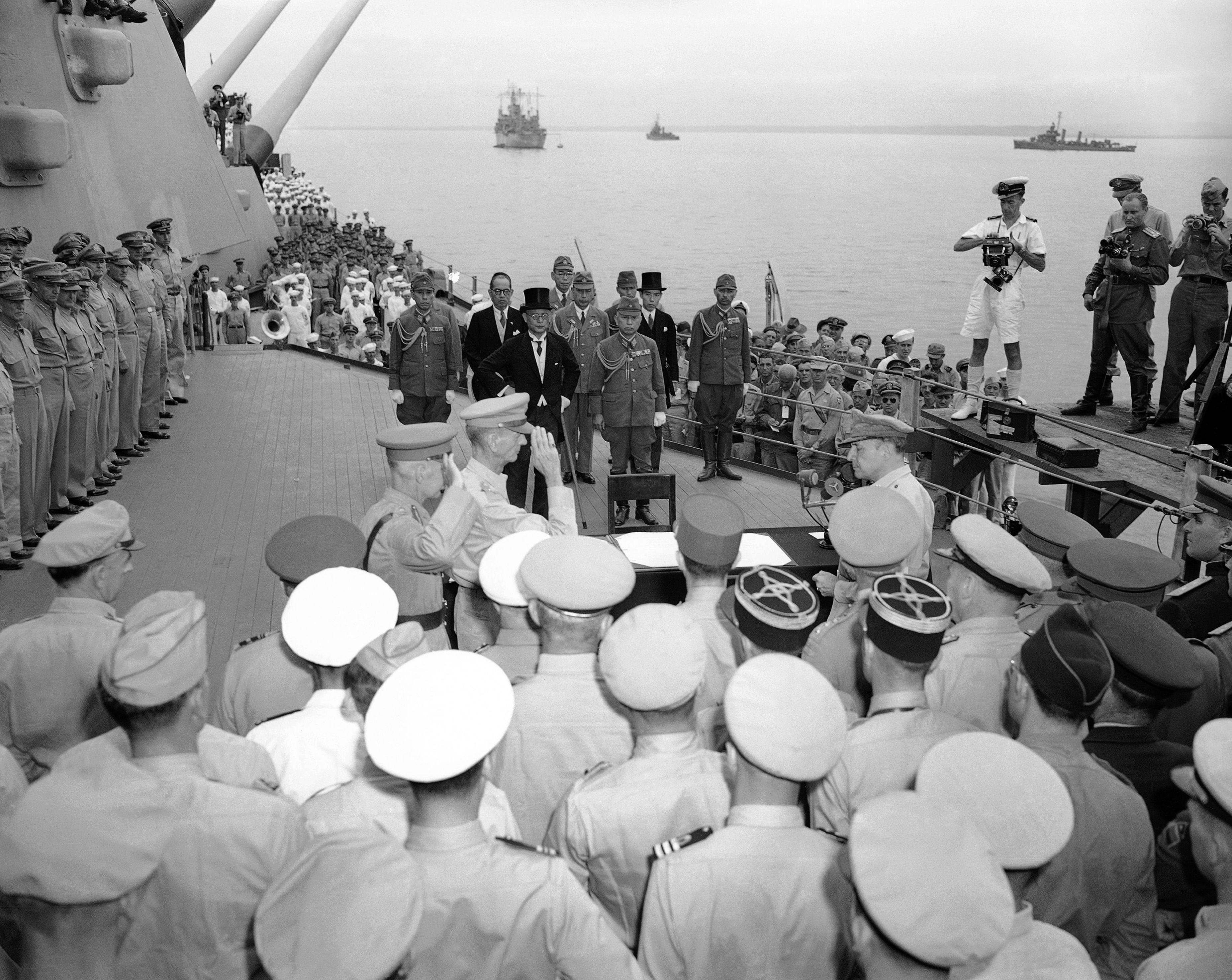 El  2 de septiembre de 1945, el Teniente General  Sir Arthur Percival y el Teniente General Jonathan M. Wainwright saludan el General Douglas MacArthur antes de la firma de los últimos documentos de la rendición de Japón a bordo de la USS Missouri en la bahía de Tokio. Detrás, la delegación japonesa (AP Foto/Max Desfor, archivo)