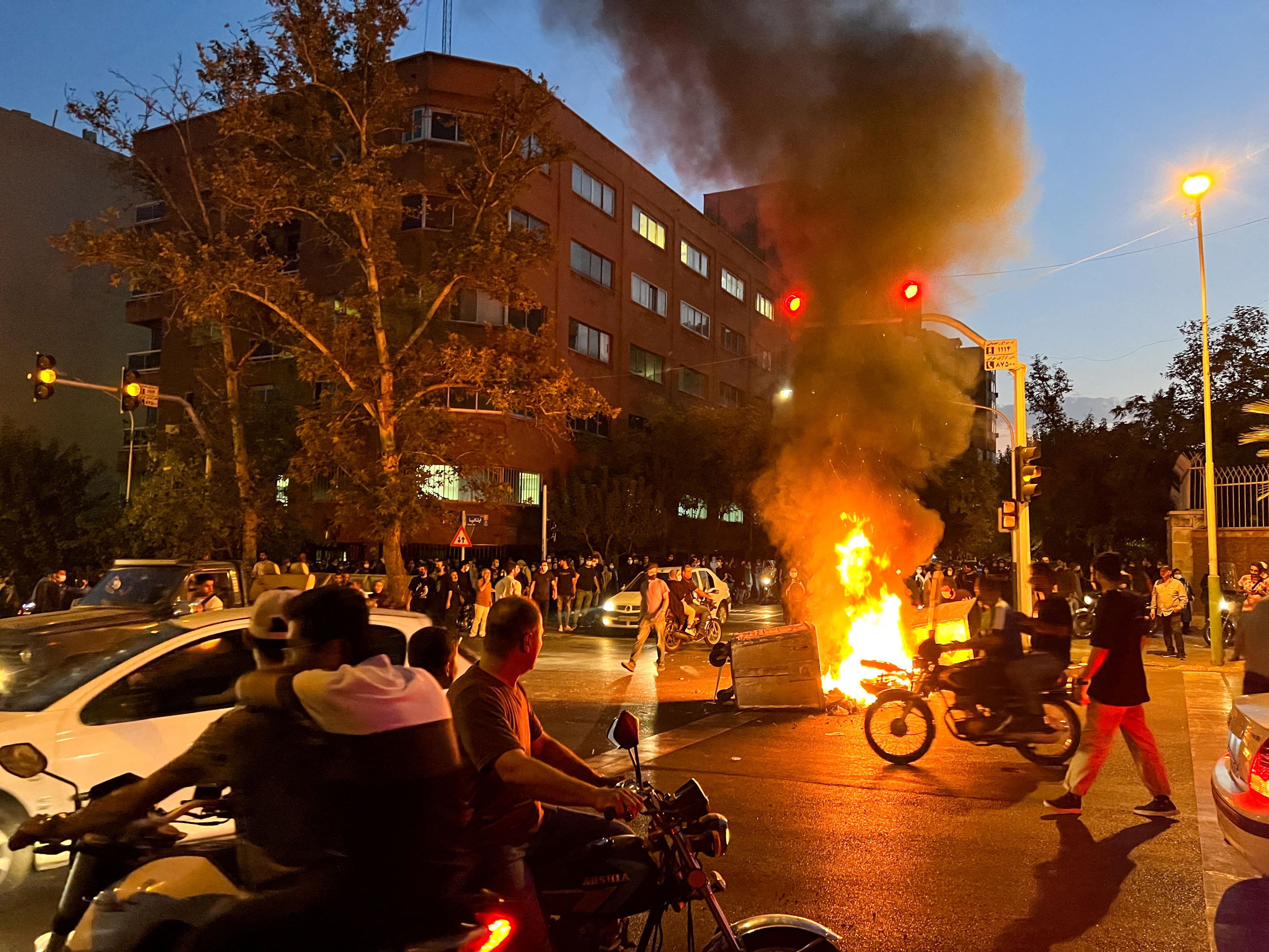 Una motocicleta de la policía arde durante una protesta por la muerte de Mahsa Amini, en Teherán, el 19 de septiembre de 2022 (West Asia News Agency via REUTERS)