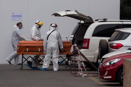 Trabajadores del Hospital San JosÃ© y operarios funerarios trasladan el cuerpo de un fallecido en Santiago (Chile). EFE/ Alberto ValdÃ©s/Archivo
