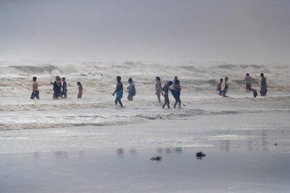 Los visitantes de la playa en Galveston, Texas, juegan con las olas del huracán Hanna el 25 de julio de 2020. REUTERS/Adrees Latif