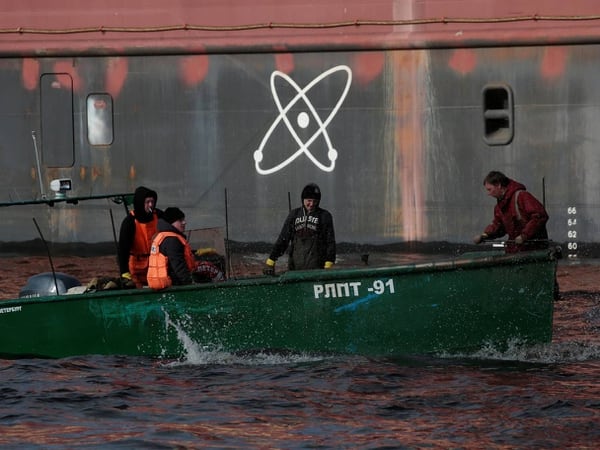 Pescadores pasan con su bote junto a la planta nuclear flotante