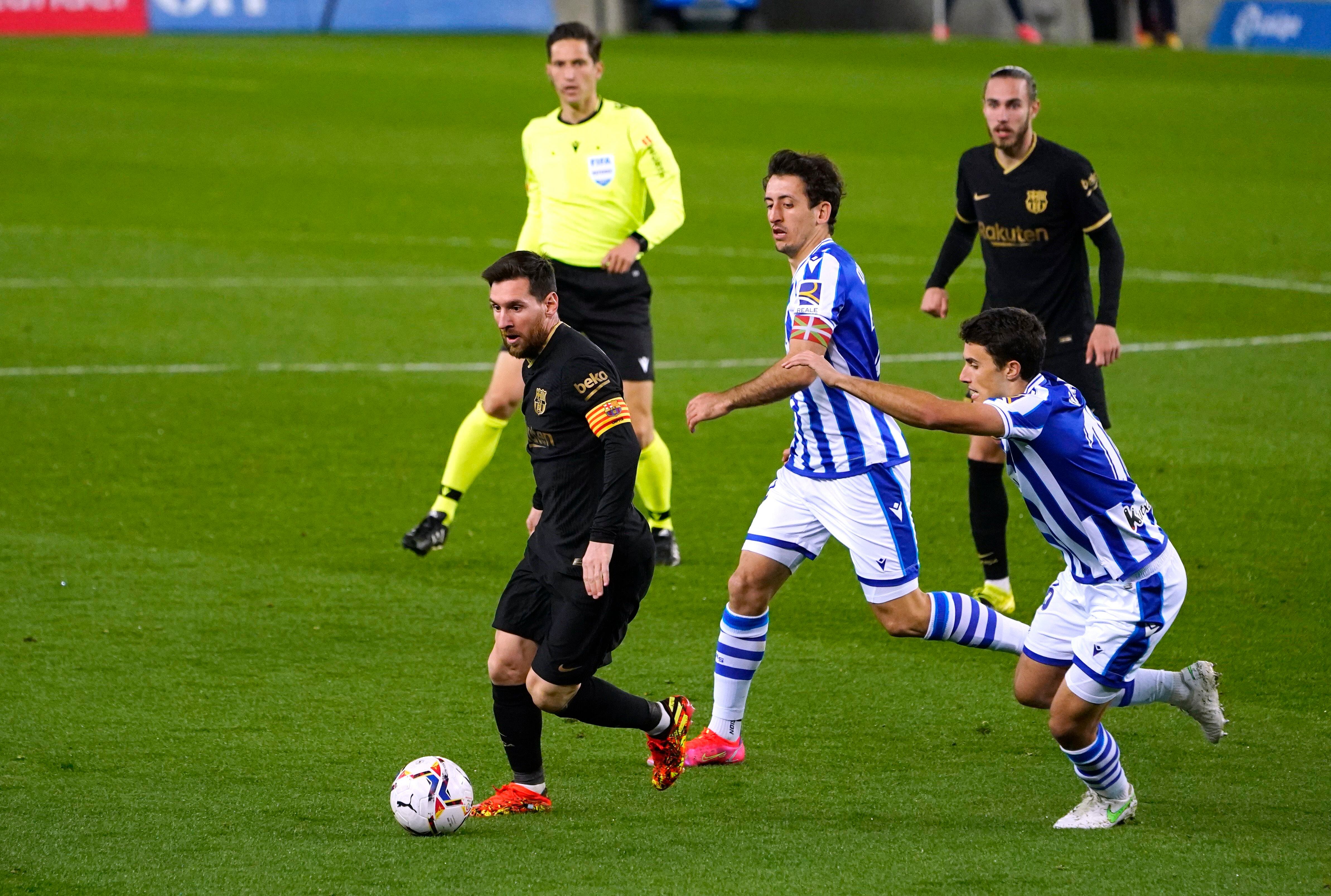 Lionel Messi escapa de la marca de Mikel Oyarzabal en un duelo entre el Barcelona y la Real Sociedad. Foto: REUTERS/Vincent West