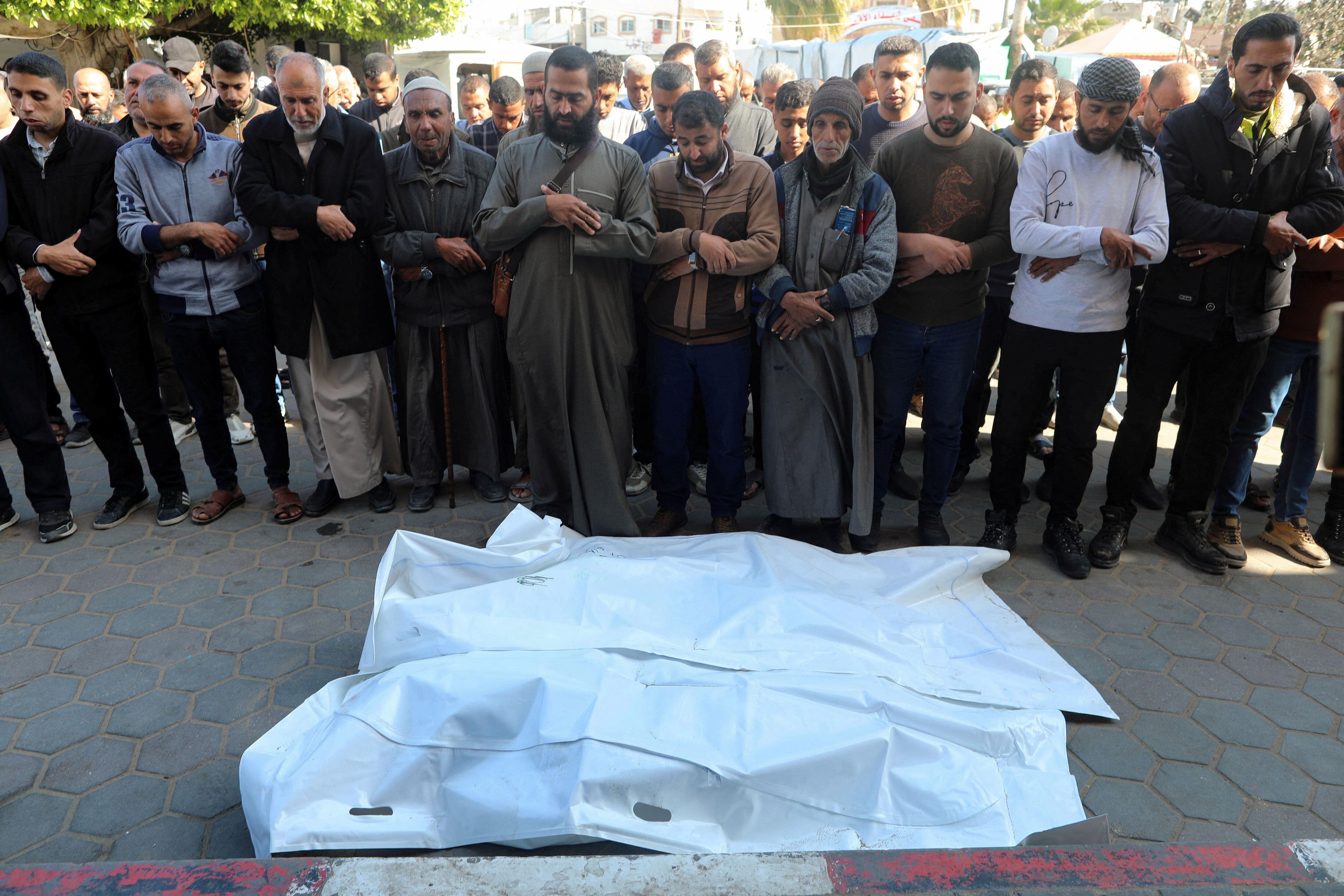 Los dolientes rezan junto a los cuerpos de los palestinos muertos en el ataque, entre ellos el de Hatem Al-Ghamri, alcalde de Maghazi. (REUTERS/Ramadan Abed)