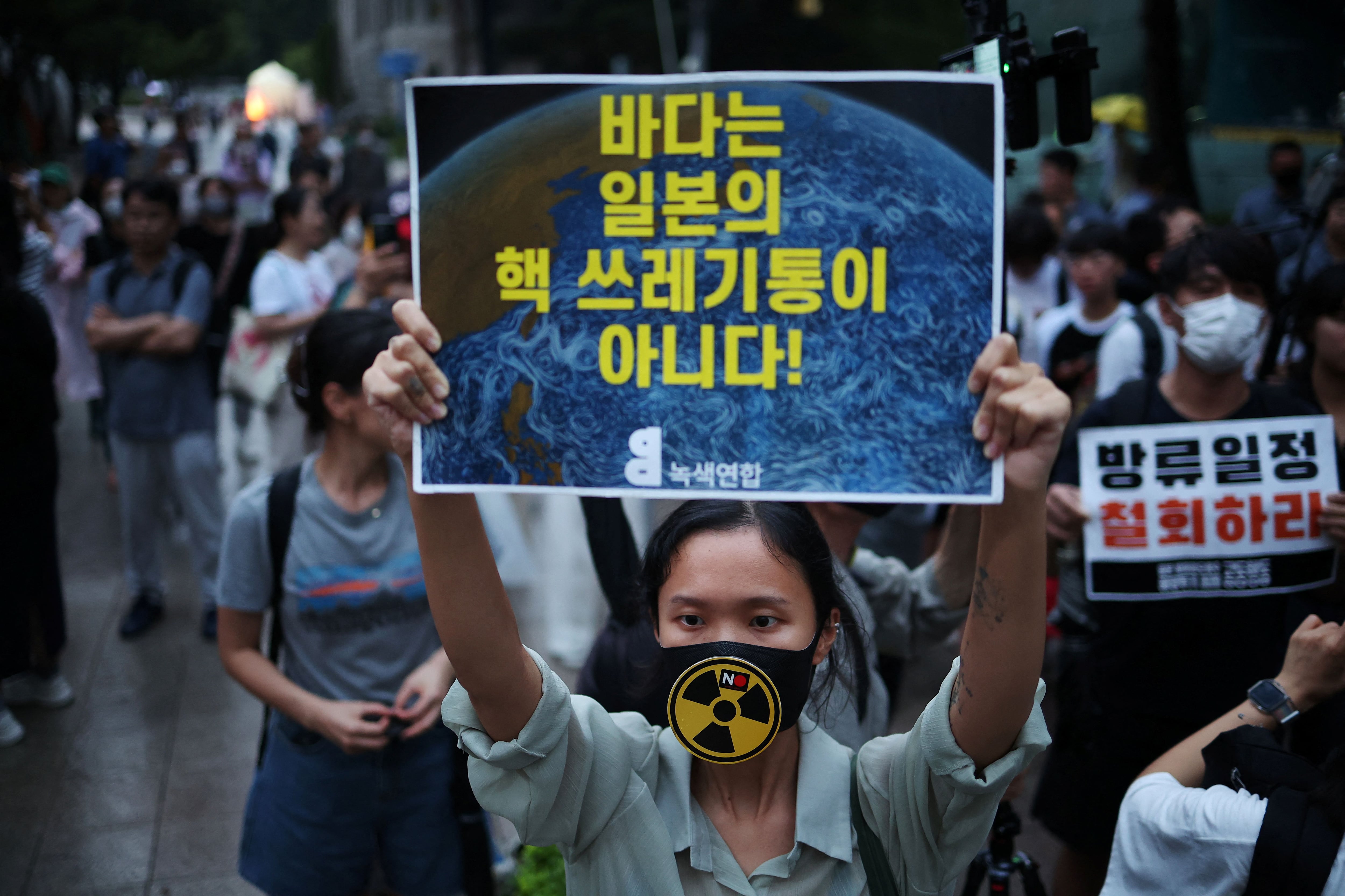 Una mujer sostiene un cartel que dice "¡El océano no es un basurero para desechos nucleares!" Durante una protesta contra el plan de Japón de liberar al océano aguas residuales tratadas de la central nuclear de Fukushima, en el centro de Seúl, Corea del Sur, el 22 de agosto de 2023. REUTERS/Kim Hong-Ji