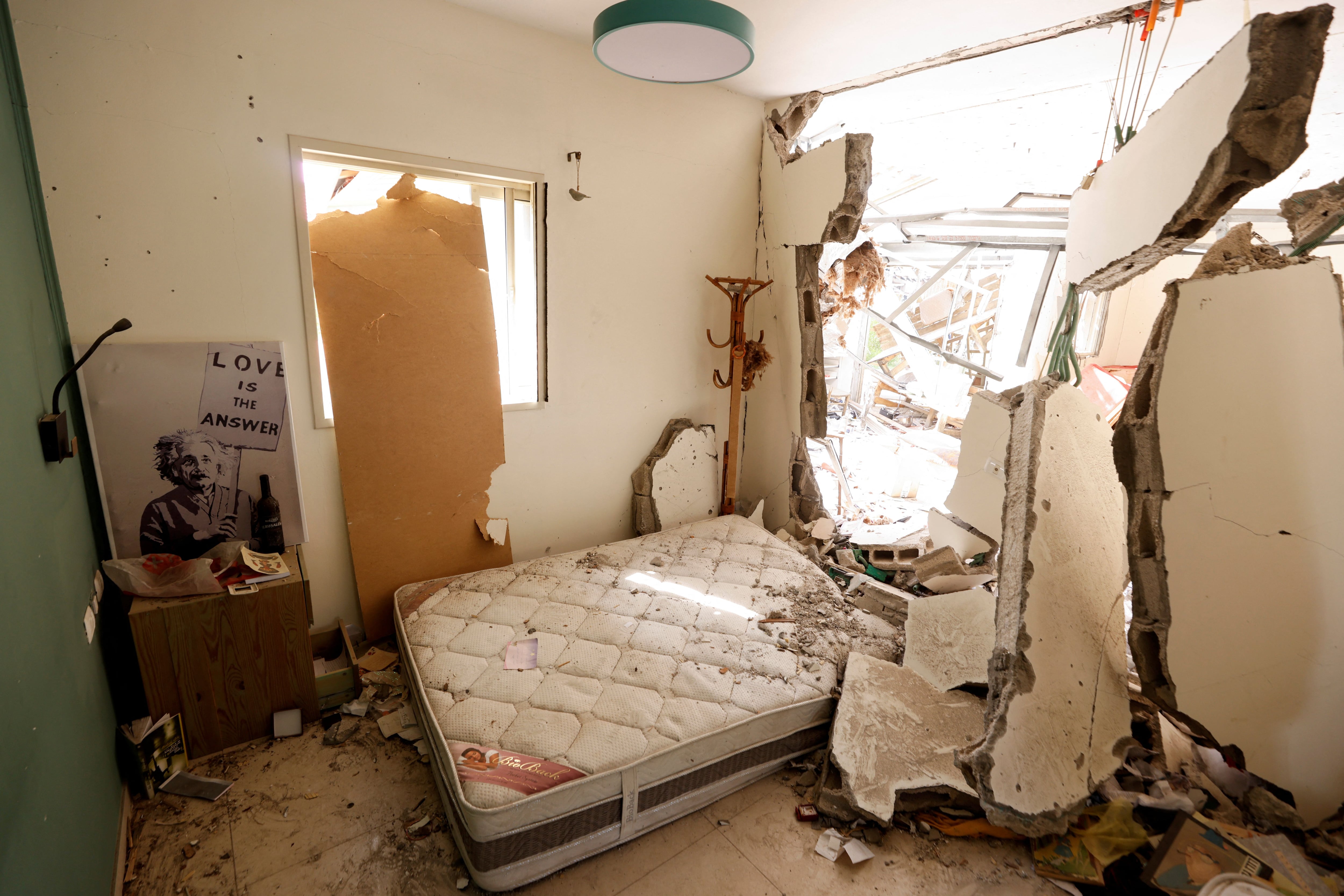 Un cuadro de Albert Einstein sosteniendo un cartel con las palabras "el amor es la respuesta" se ve en un dormitorio destruido, después de una infiltración masiva de terroristas de Hamas desde la Franja de Gaza, en el kibutz Beeri en el sur de Israel, 13 de octubre de 2023 (Reuters- Amir Cohen) 