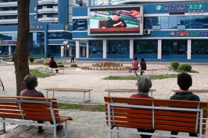 Unas personas ven noticias relacionadas con el presidente norcoreano Kim Jong Un en un parque en Pyongyang, Corea del Norte, el 2 de mayo de 2020. (AP Foto/Cha Song Ho)