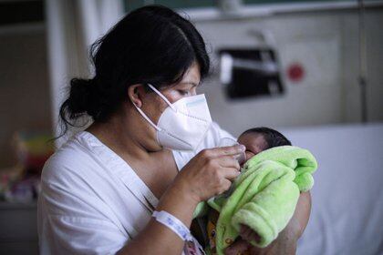 Una mujer contagiada de coronavirus junto a su bebé en México (REUTERS/Luis Cortes)
