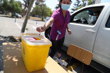 Un trabajador de la salud descarta una jeringa desechable después de administrar una dosis de la vacuna contra la enfermedad del coronavirus CoronaVac de Sinovac en un centro de vacunación en Santiago, Chile, el 26 de febrero de 2021 (Reuters)