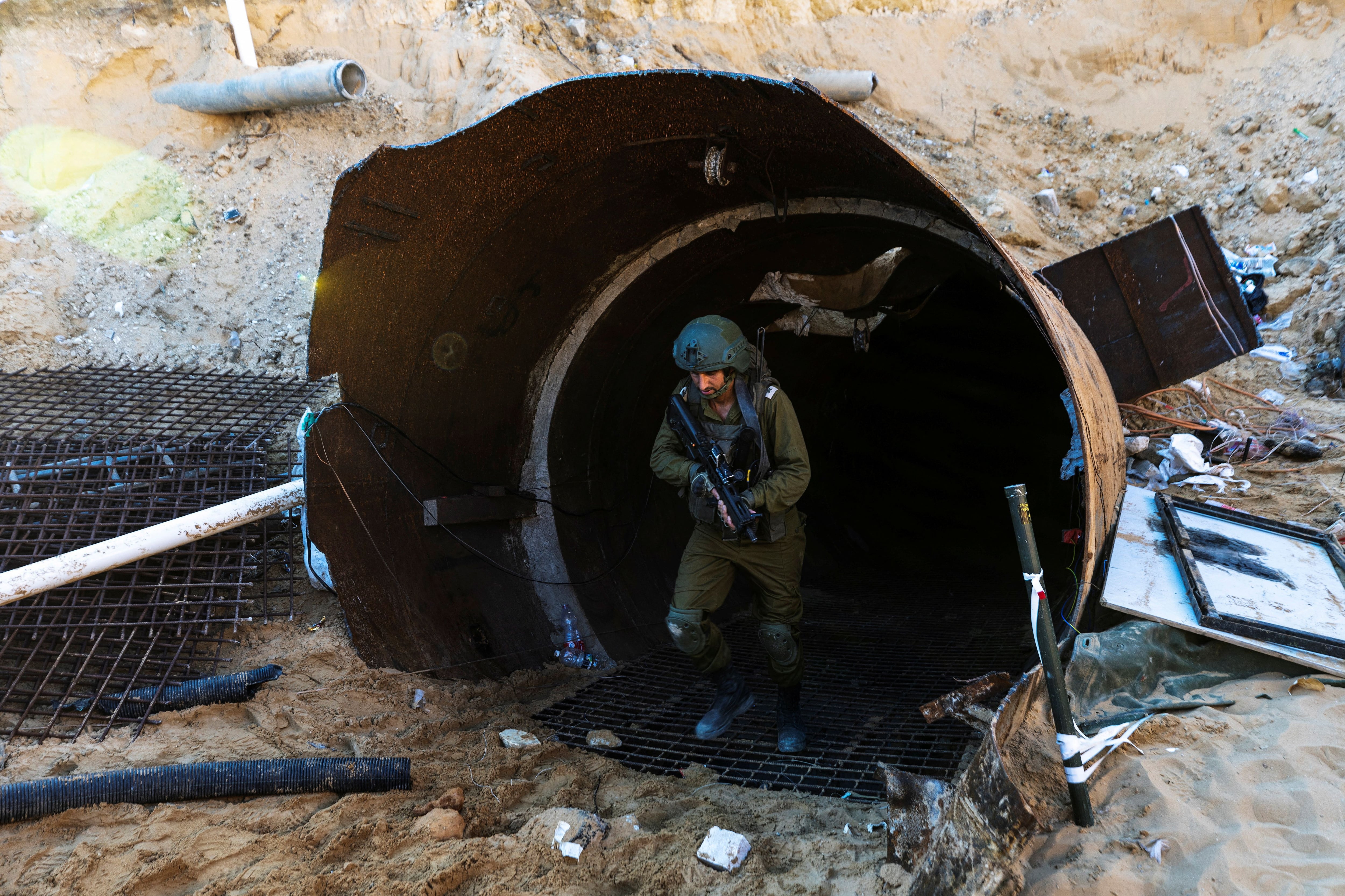 An Israeli soldier operates at the opening to what Israel's military says is an iron-girded tunnel designed by Hamas to disgorge carloads of Palestinian fighters for a surprise storming of the border, amid the Israeli army's ongoing ground operation against Palestinian Islamist group Hamas, close to Erez crossing in the northern Gaza Strip, December 15, 2023. REUTERS/Amir Cohen