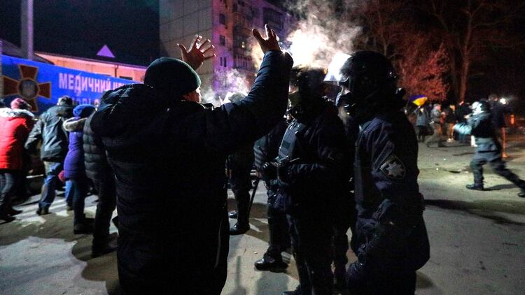Manifestantes se enfrentaron con la policía por los evacuados de Wuhan que llegaron a Ucrania para cumplir con la cuarentena (Photo by STR / AFP)