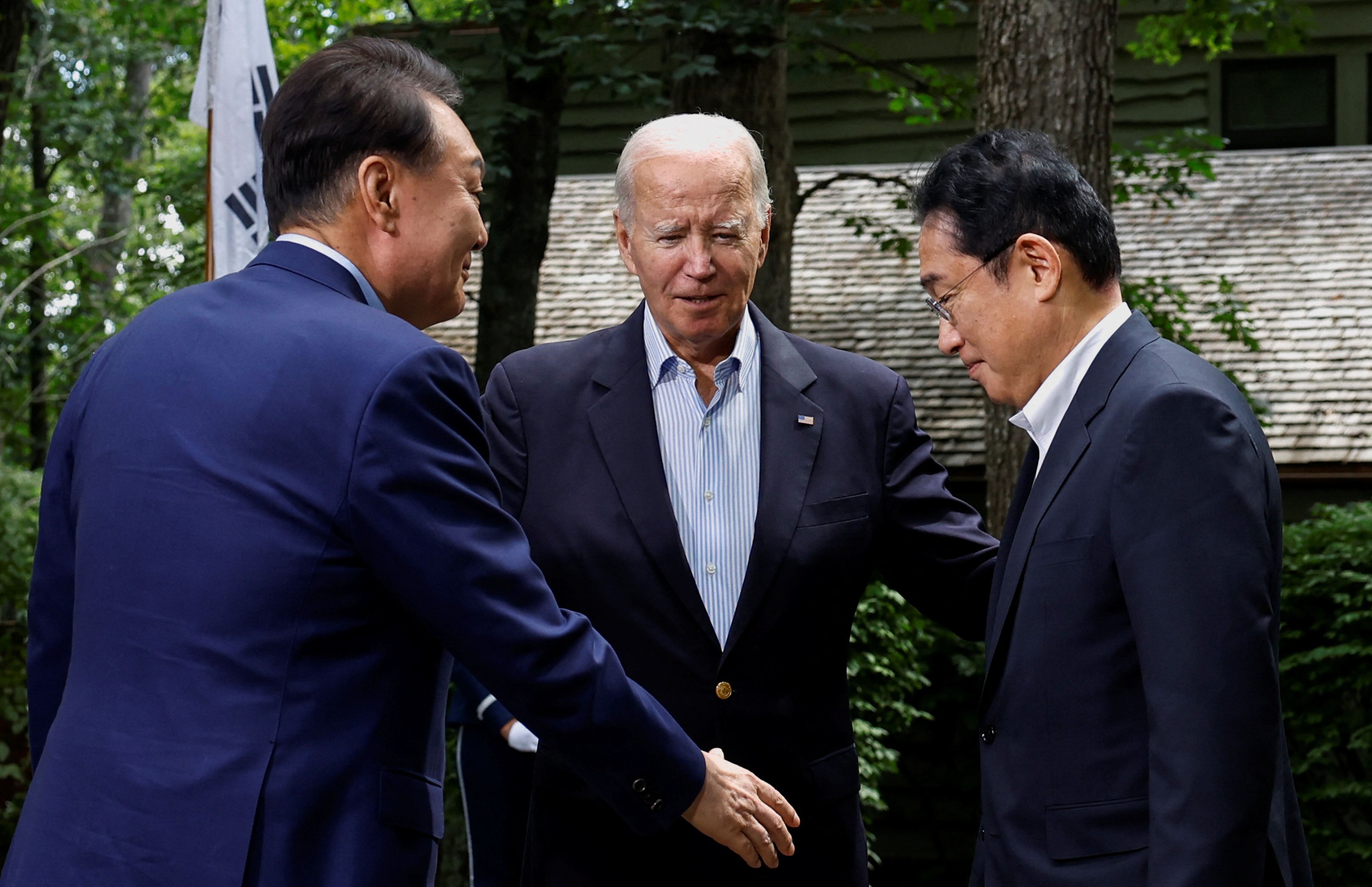 El presidente estadounidense Joe Biden saluda al primer ministro japonés Fumio Kishida y al presidente surcoreano Yoon Suk Yeol durante la cumbre trilateral en Camp David cerca de Thurmont, Maryland, EE. UU., 18 de agosto de 2023. REUTERS/Evelyn Hockstein