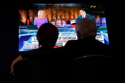 Una pareja mira los resultados por la televisión.   REUTERS/Brian Snyder