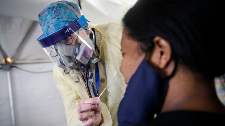 Catherine Hopkins, Directora de Alcance Comunitario y Salud Escolar en el Hospital St. Joseph, realiza un hisopo COVID-19 en una paciente (AP/John Minchillo)