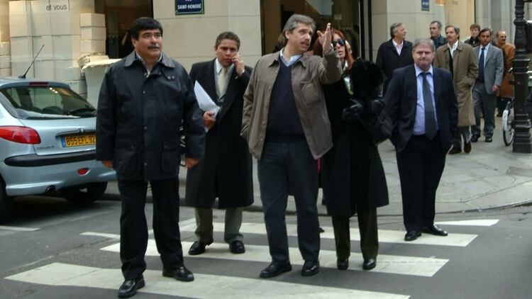 Fabián Gutiérrez con un teléfono en sus manos, rodeado por Carlos Zannini, Alberto Fernández, Cristina Kirchner y Daniel Muñoz. En el fondo, Néstor Kirchner y Felipe Solá