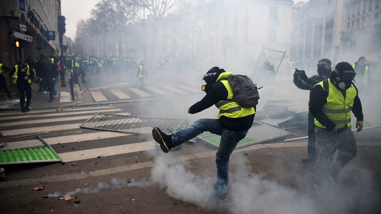 Una manifestante equipado con una mÃ¡scara de gas patea una bomba de gas lacrimÃ³genoÂ (AFP)