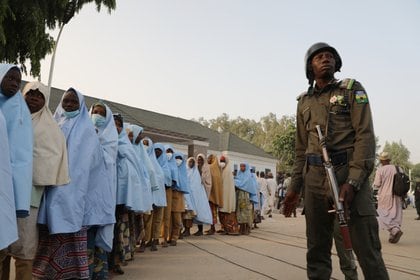 Un soldado junto a un grupo de niñas previamente secuestradas en su internado en el norte de Nigeria  (Foto de - / AFP)