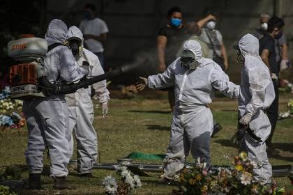 Los sepultureros se desinfectan después de enterrar un cuerpo en Managua, Nicaragua, el 16 de mayo de 2020. (Inti Ocon/The New York Times)
