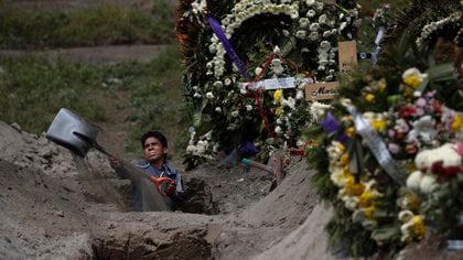 El trabajador de un cementerio cava una tumba en una sección del Cementerio Municipal de Valle de Chalco que se abrió a inicios de la pandemia de coronavirus para lidiar con el aumento de decesos, a las afueras de la Ciudad de México, el jueves 24 de septiembre de 2020.  (AP Foto/Rebecca Blackwell)