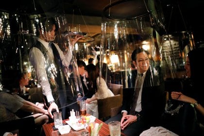 Imagen de pantallas de acrílico similares a una pecera instaladas en un bar como parte de las nuevas medidas de distanciamiento social y prevención de infecciones contra el coronavirus en el distrito de Ginza, en Tokio, Japón (REUTERS/Issei Kato)