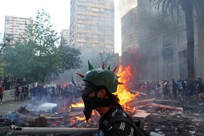 Una persona participa en una protesta contra el gobierno de Chile, en el primer aniversario de las protestas y disturbios que sacudieron la capital en 2019, en Santiago de Chile.. REUTERS/Ivan Alvarado