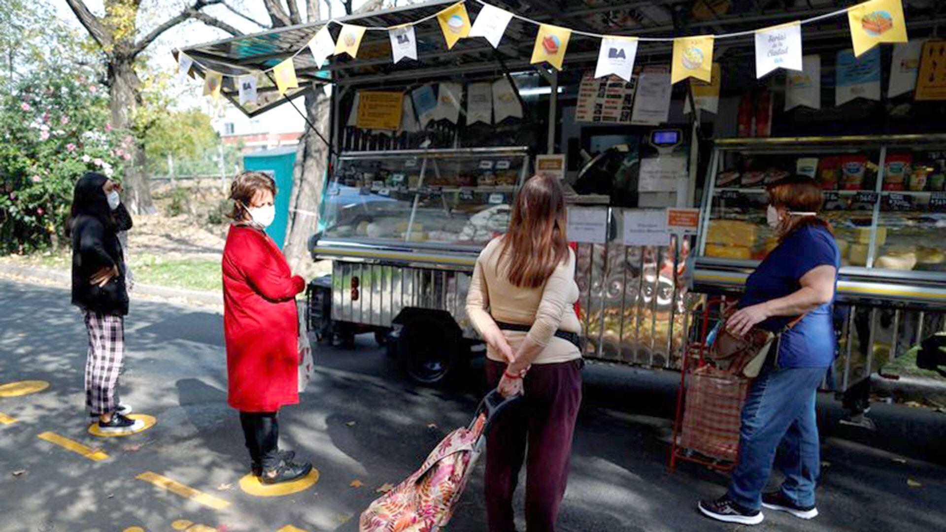 Personas con distanciamiento en un mercado callejero de Buenos Aires, en momentos que el  COVID-19 afecta a los mercados financieros