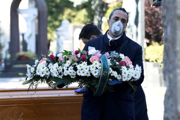 Trabajadores de un cementerio de Bérgamo transportan el ataúd de una de las víctimas del coronavirus. (Reuters)