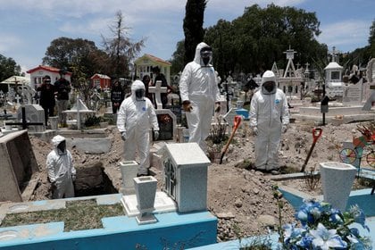 Imagen de archivo. Trabajadores de un cementerio usando trajes protectores completan el entierro de un hombre, que murió de COVID-19, en el Estado de México, México. 19 de junio de 2020. REUTERS/Henry Romero