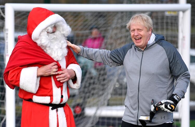 Johnson saluda a un hombre vestido de Papá Noel (REUTERS/Toby Melville/Pool)