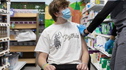 Max Dobles, 17, who has Crohn's disease, looks at Dr. Mayank Amin before receiving the Pfizer-BioNTech vaccine against the coronavirus disease (COVID-19) at Skippack Pharmacy in Schwenksville, Pennsylvania, U.S., March 3, 2021. Picture taken March 3, 2021.  REUTERS/Hannah Beier