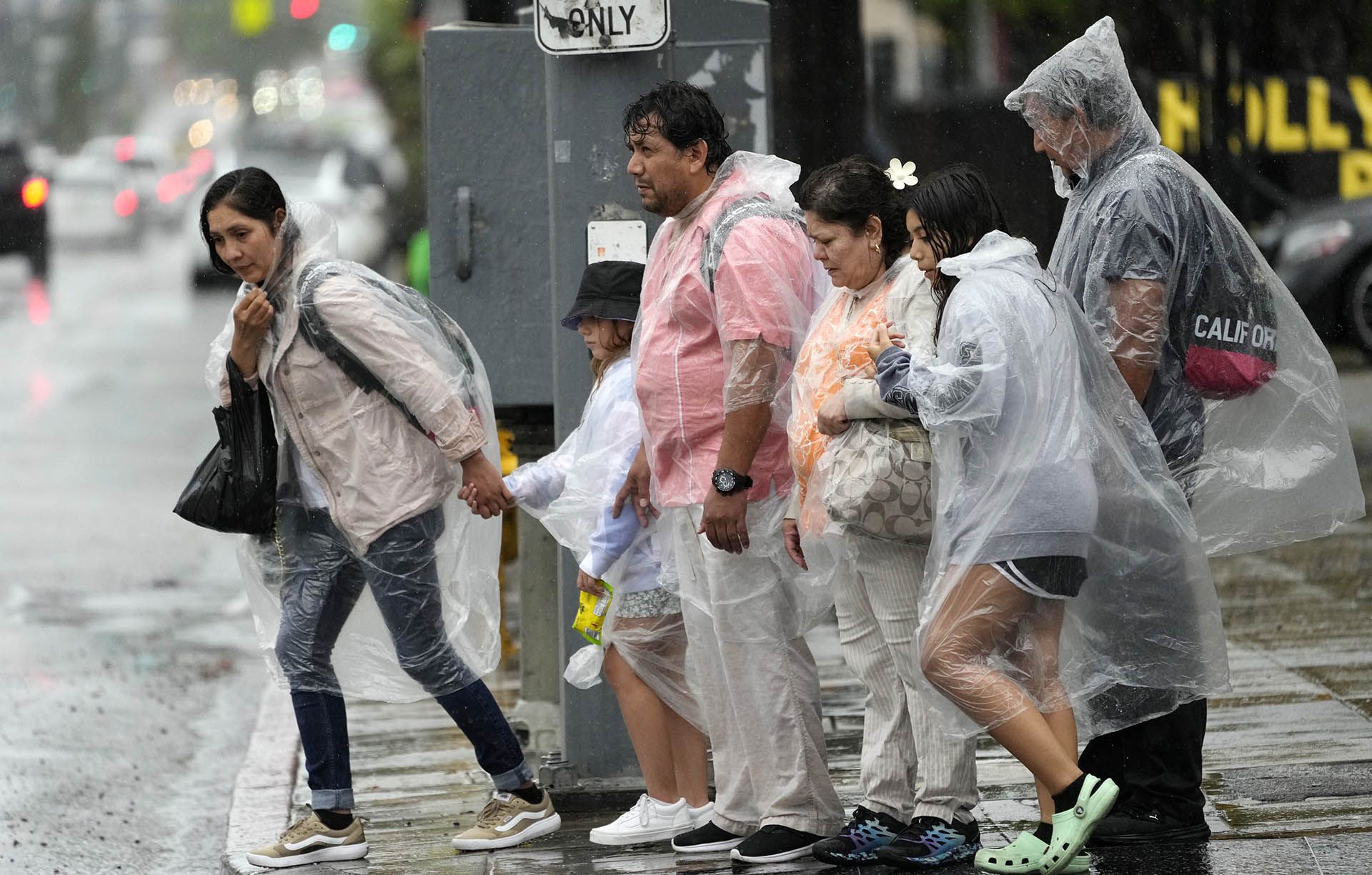 Los peatones luchan contra los fuertes vientos y la lluvia en Hollywood Boulevard.