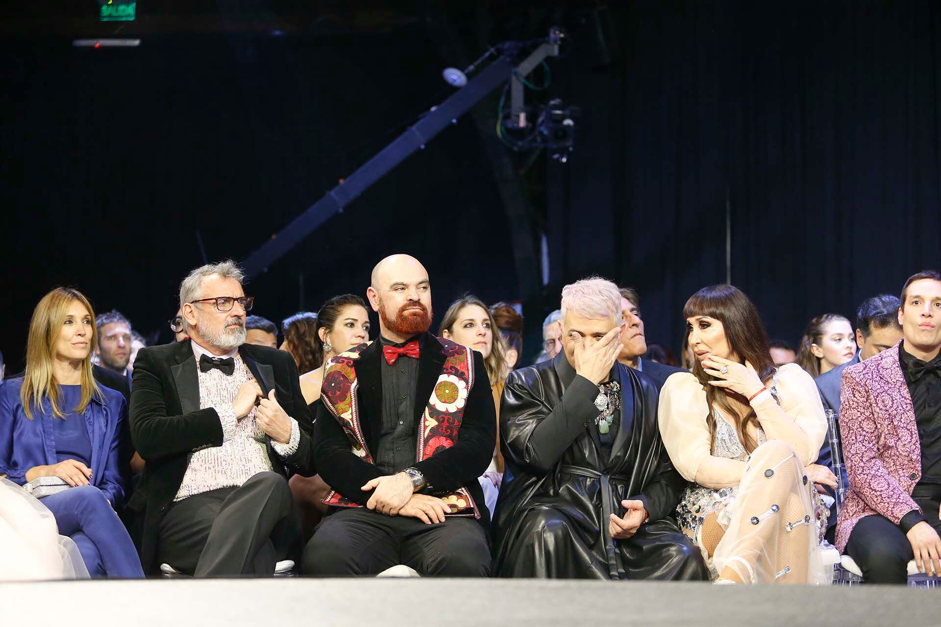 Benito Fernández, su novio Zeus y Moria rodeada de sus colaboradores. En esa fila nadie dejó de comentar lo que ocurría arriba y abajo del escenario