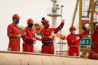 Trabajadores de PDVSA sosteniendo banderas de Irán y Venezuela tras el arribo del taquero iraní "Fortune" a la refinería El Palito. 
May 25, 2020. Palacio Miraflores/Handout via REUTERS