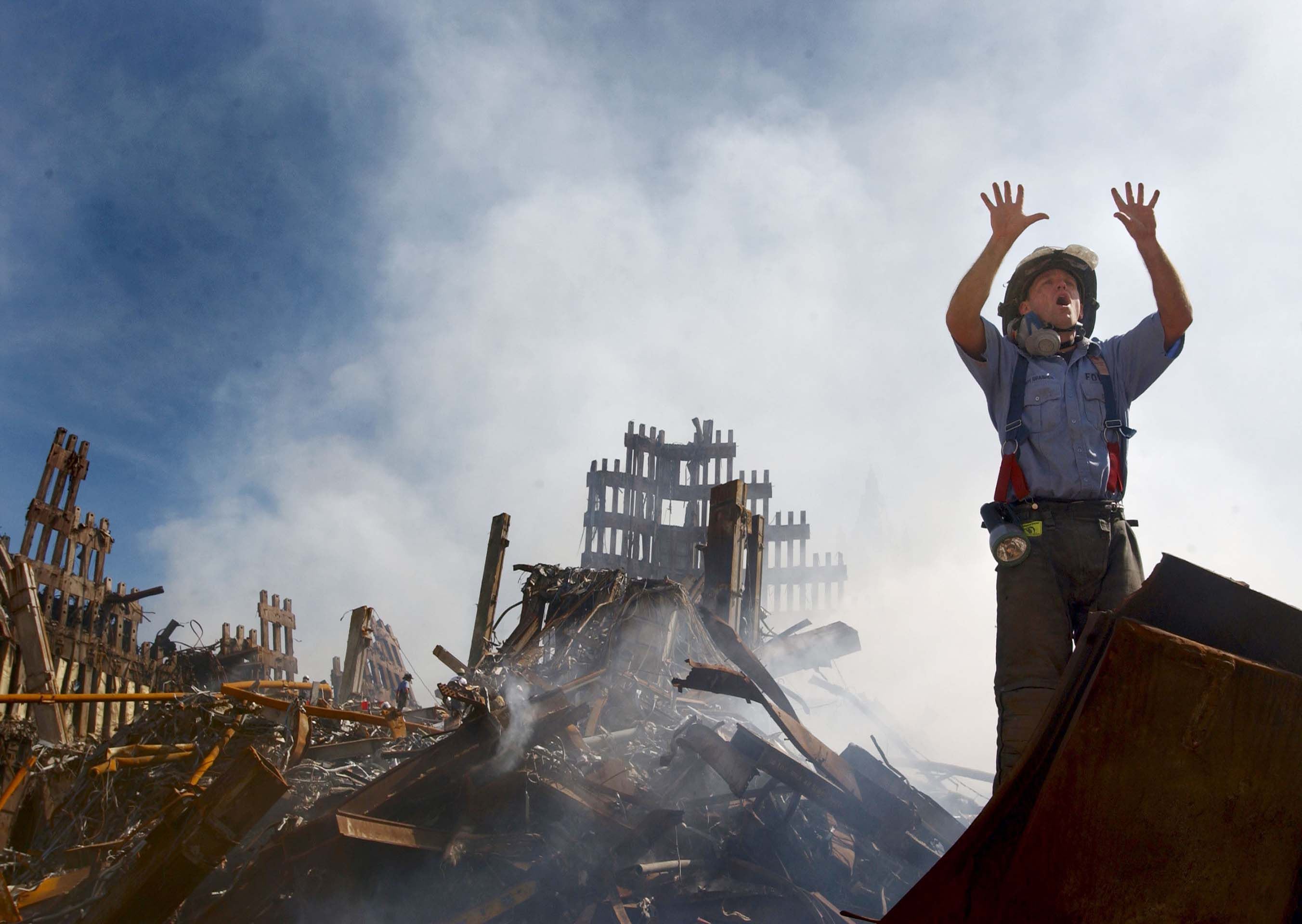 Un bombero pide ayuda a otros díez compañeros. La escena corresponde a los días posteriores al atentado, cuando aún buscaban sobrevivientes. (Foto: Preston Keres/Getty Images)