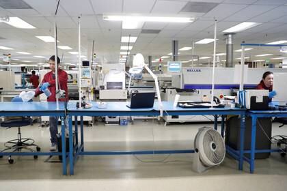 Trabajadores desinfectan una línea de producción mientras mantienen el distanciamiento social en una planta en San José, California, el 2 de abril de 2020 (REUTERS/Stephen Lam)