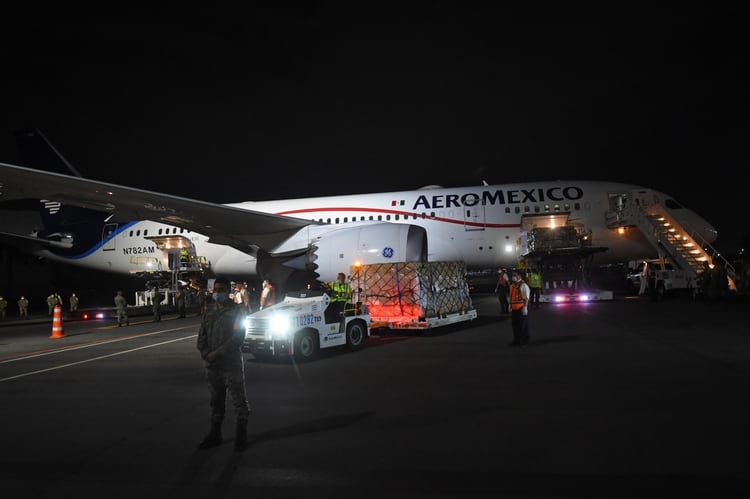Soldados mexicanos esperan mientras una carga de equipo de protección personal enviada por China a México para ayudar en la lucha contra la nueva pandemia de coronavirus se descarga de un avión a su llegada al aeropuerto de Ciudad de México el 7 de abril de 2020. PEDRO PARDO / AFP