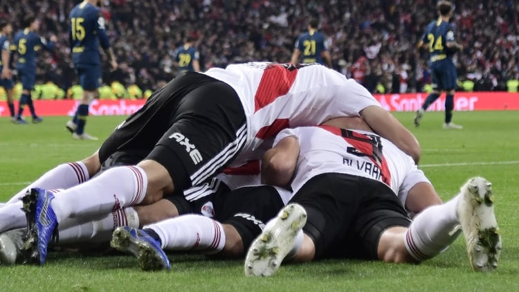 River Plate’s Colombian Juan Fernando Quintero (covered) celebrates with teammates after scoring against Boca Juniors during the second leg match of the all-Argentine Copa Libertadores final, at the Santiago Bernabeu stadium in Madrid, on December 9, 2018. (Photo by Javier SORIANO / AFP)