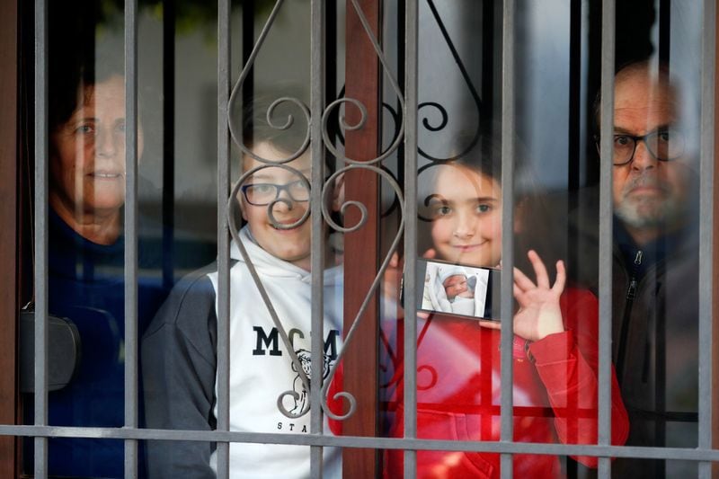 Una familia tras la ventana de su casa durante el confinamiento impuesto a escala nacional en España para tratar de contener la pandemia de COVID-19, en Andalucía, España (Reuters/Jon Nazca)