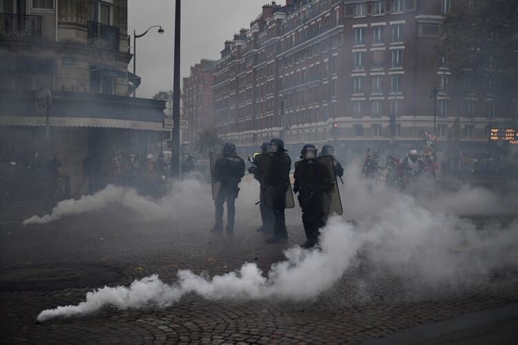 La policía antidisturbios se encuentra en medio de gases lacrimógenos cerca de la Puerta de Champerret (Foto de MARTIN BUREAU / AFP)