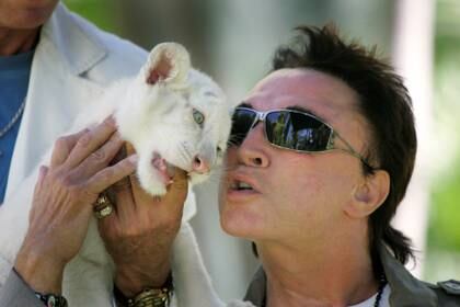 Roy Horn posa con un tigre blanco cachorro