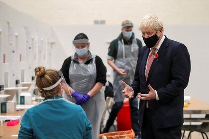 El primer ministro británico Boris Johnson habla con personal médico en el centro de testeo de la De Montfort University en Leicester (REUTERS/Molly Darlington)