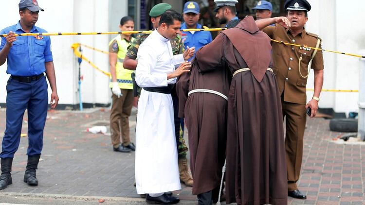 Miembros del clero se lamentan frente a una de las iglesias atacadas (Reuters)