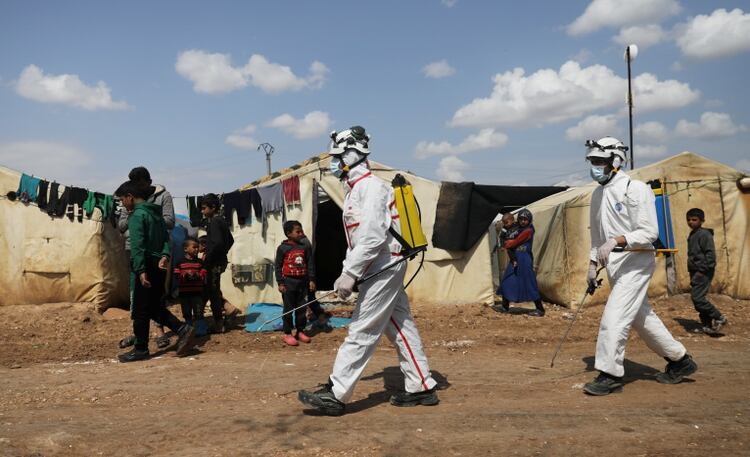 Miembros de la Defensa Civil de Siria desinfectan el campamento de desplazados internos de Bab Al-Nour para prevenir la propagaciÃ³n del coronavirus, en Azaz, Siria (REUTERS/Khalil Ashawi)