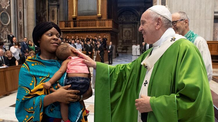 El papa acaricia una niña durante la misa que se celebró este lunes. (Reuters)