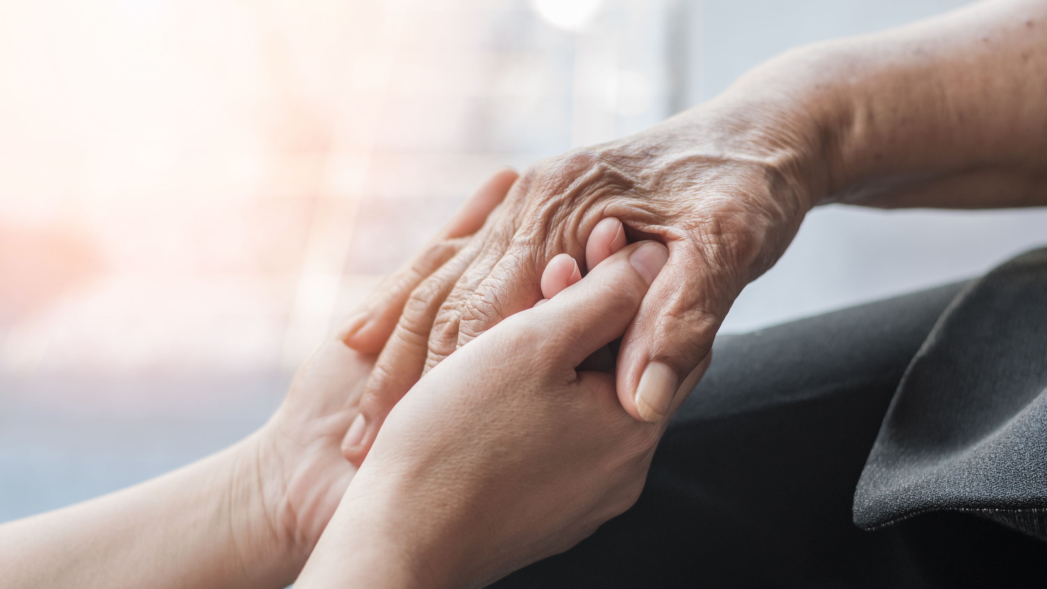 Una mujer sostiene la mano de un paciente de Alzheimer (Shutterstock)