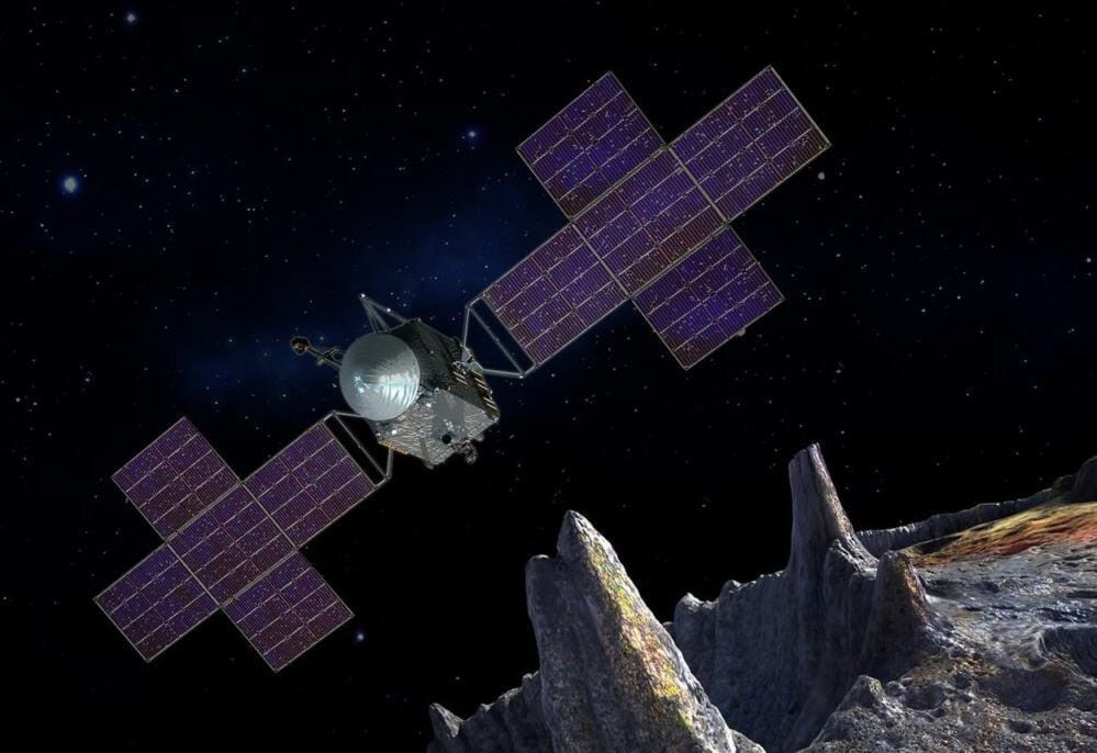 Un'illustrazione concettuale di un artista che raffigura la navicella spaziale per la missione Psyche della NASA vicino all'obiettivo della missione, un asteroide metallico.  (una pentola)