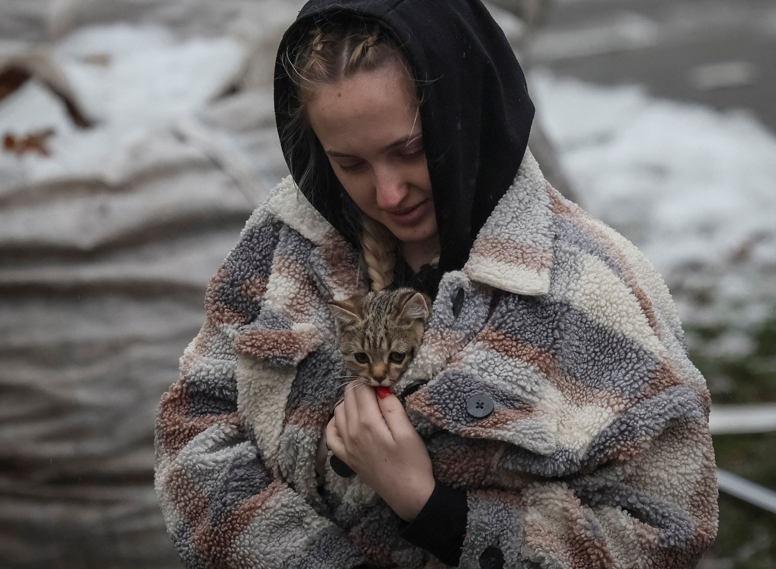 Una residente local lleva un gatito encontrado en un edificio residencial destruido por un ataque con misiles rusos en la ciudad de Vyshhorod, cerca de Kiev. (REUTERS/Gleb Garanich)