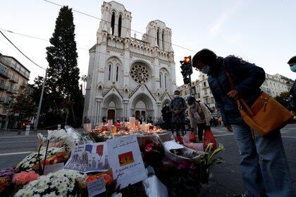 Candles and flowers are seen near the Notre Dame church in tribute to the victims of a deadly knife attack in Nice, France, October 30, 2020. REUTERS/Eric Gaillard