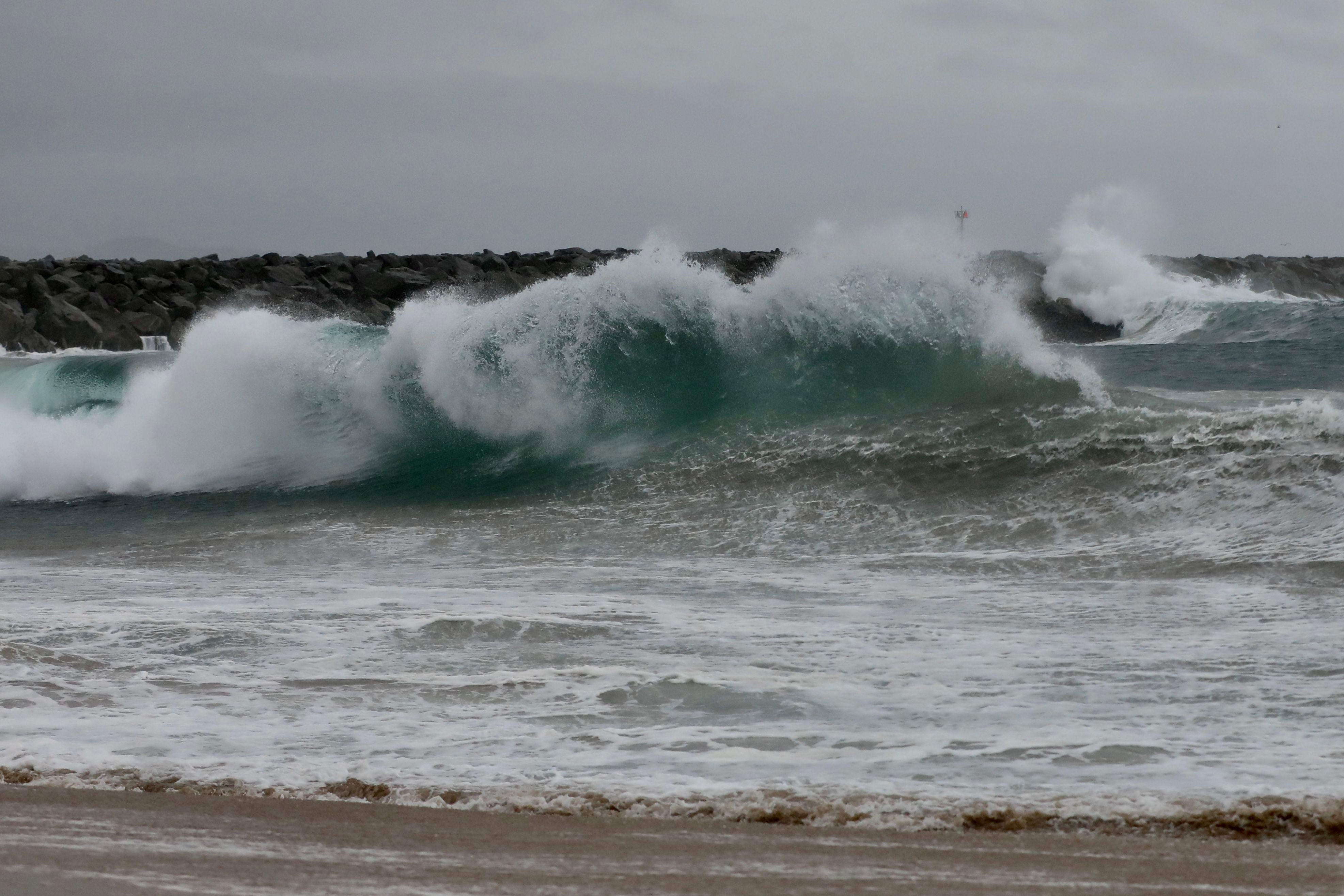 Enormes olas rompen en una playa en Newport Beach, California